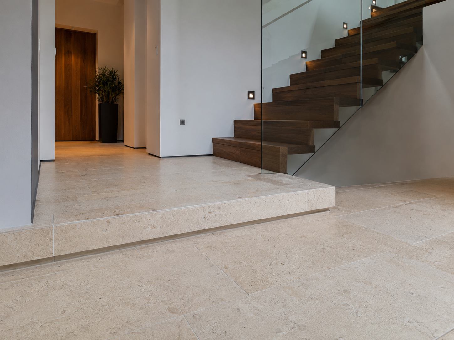 Moderner Eingangsbereich mit Holztreppe und Natursteinboden